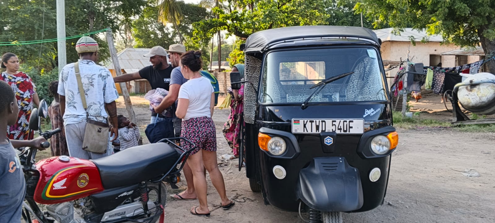 Mose greeting guests next to his tuk tuk in a Watamu village