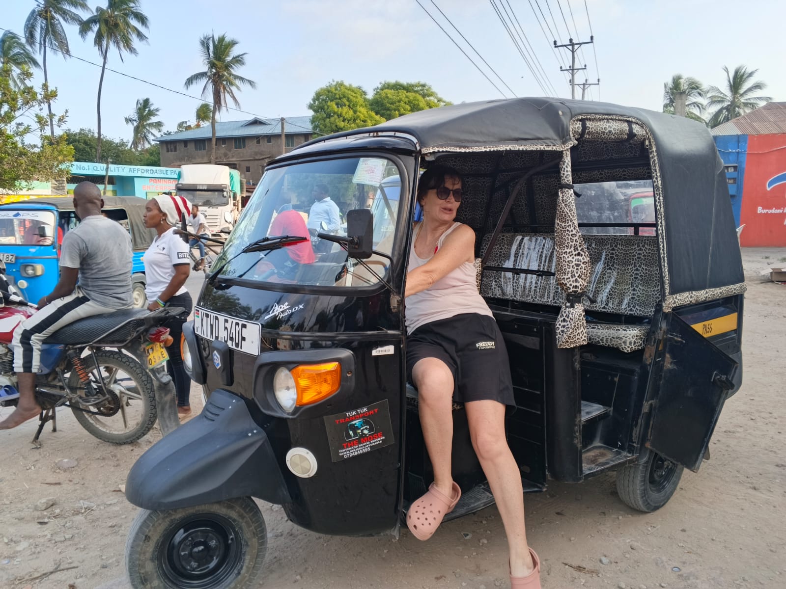Tourist sitting in Mose's black tuk tuk in Watamu town, Kenya
