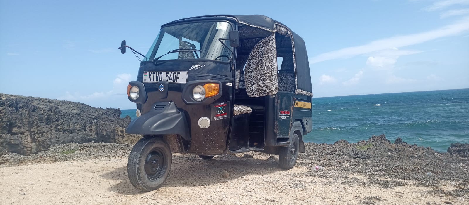 Mose's tuk tuk parked at the ocean cliffs near Watamu